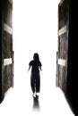 Woman walking into the light through open big door Royalty Free Stock Photo